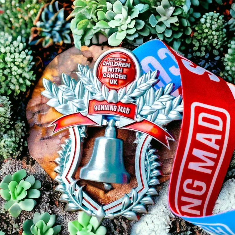 Running Mad charity medal for Children with Cancer UK on a stone surface.