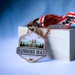 Challenge Your Limits 5k Run medal on wooden block against blue background.
