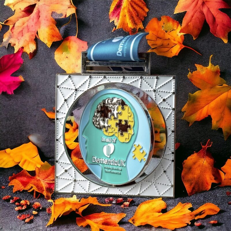 Dementia charity medal with autumn leaves background