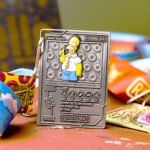 The Simpsons Series fun challenge medal with Homer Simpson and doughnuts