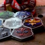 Collection of superhero-themed running medals on rustic background