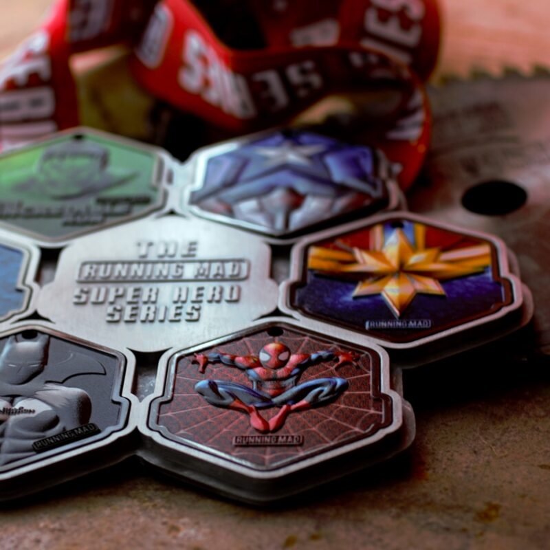 Collection of superhero-themed running medals on rustic background