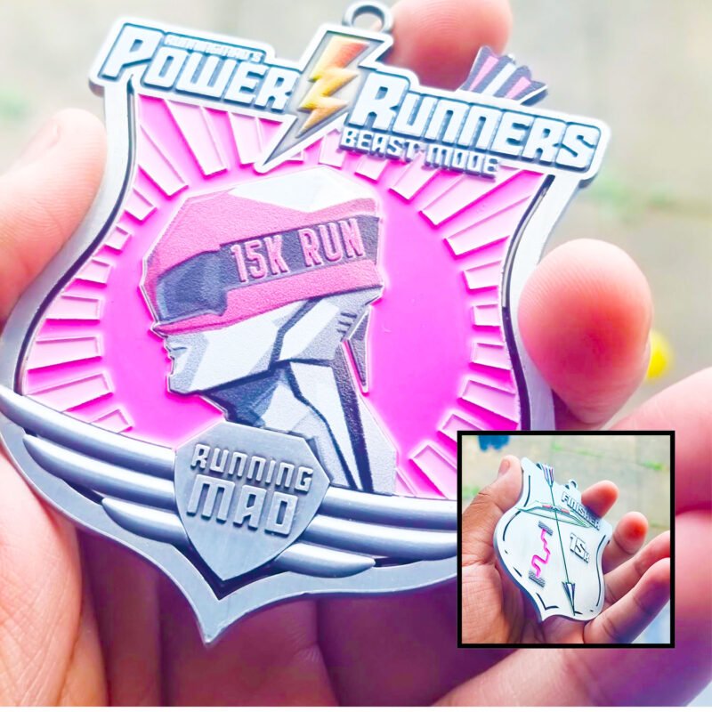 Runner holding Power Runners Pink 15K Run medal