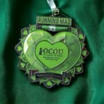 Running Mad medal with OCOU logo, celebrating 100 miles run for Yemen, on a festive background.
